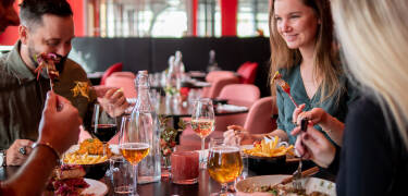 Spis godt i godt selskab med generøse måltider i hotellets italiensk-amerikanske restaurant.