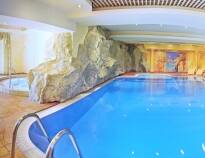 Indoor pool featuring counter flow and waterfall, plus an outdoor pool, sauna, jacuzzi, and steam bath.