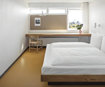 Nyd funktionelt dansk design overalt på hotellet, med værelser der afspejler 1960’ernes enkle og praktiske arkitektur.
