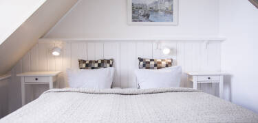Rommene på Hotel Klostergaarden er preget av autentisk feriehussjarm og kombinerer historie med komfort for et minneverdig opphold.