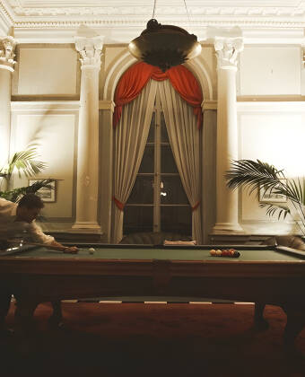Unwind in social spaces with billiards, classic drinks and castle ambience.