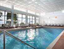 I hotellets innendørs svømmebasseng kan dere slappe av og nyte den vakre utsikten over havet og strandpromenaden.