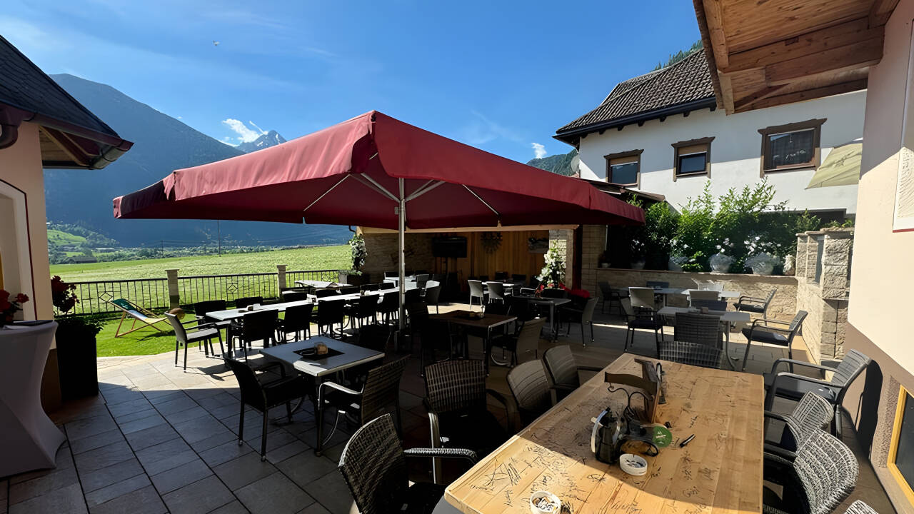 Entspannen Sie auf der Hotelterrasse und genießen Sie nach einem aktiven Tag die Aussicht auf die Gipfel.