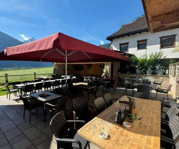 Entspannen Sie auf der Hotelterrasse und genießen Sie nach einem aktiven Tag die Aussicht auf die Gipfel.