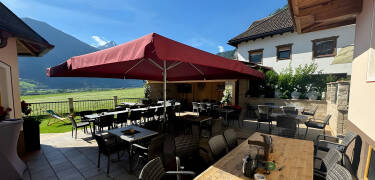 Entspannen Sie auf der Hotelterrasse und genießen Sie nach einem aktiven Tag die Aussicht auf die Gipfel.