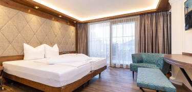 Wohnen Sie in hellen, einladenden Zimmern im Alpenstil mit viel Charme und Bergblick.