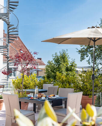The hotel's sunny courtyard invites you to relax with a refreshing drink.