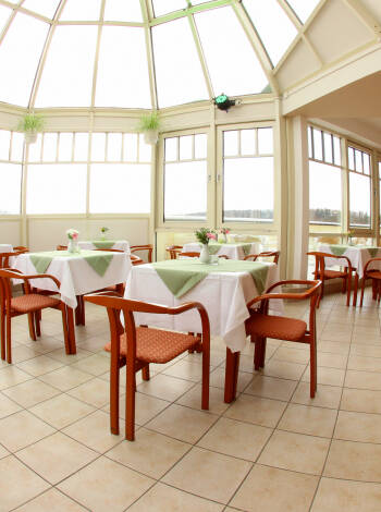 Genießen Sie ein Essen im sonnigen Restaurant mit malerischer Aussicht.