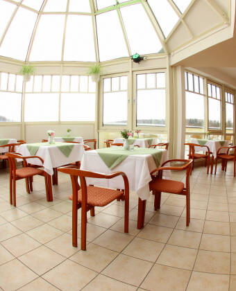 Enjoy dining in the sunlit restaurant with a picturesque view.