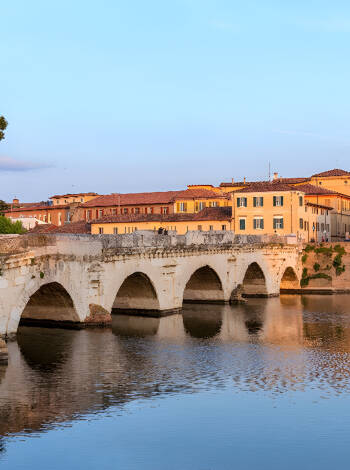 Schlendern Sie über die historische Tiberiusbrücke in Rimini, die im 14. f.Kr unter Kaiser Augustus erbaut wurde.