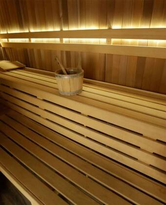 In der Sauna kannst du dich aufwärmen und entspannen, wodurch dein Körper zur Ruhe kommt und die Müdigkeit des Tages hinter sich lässt.