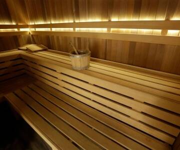 In der Sauna kannst du dich aufwärmen und entspannen, wodurch dein Körper zur Ruhe kommt und die Müdigkeit des Tages hinter sich lässt.