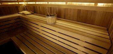 In der Sauna kannst du dich aufwärmen und entspannen, wodurch dein Körper zur Ruhe kommt und die Müdigkeit des Tages hinter sich lässt.