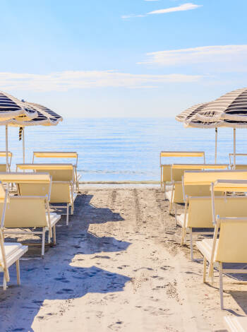 Genießen Sie den privaten Strandbereich mit Liegestühlen, Sonnenschirmen und Strandservice.