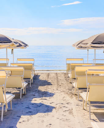 Nyd et dedikeret privat strandområde med liggestole, parasoller og strandservice.
