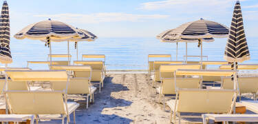Genießen Sie den privaten Strandbereich mit Liegestühlen, Sonnenschirmen und Strandservice.