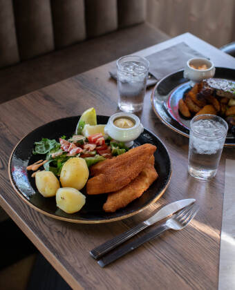 Etter en aktiv dag kan du nyte en deilig middag og slappe av i den koselige baren.