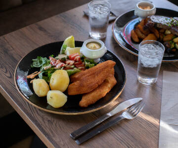 Etter en aktiv dag kan du nyte en deilig middag og slappe av i den koselige baren.