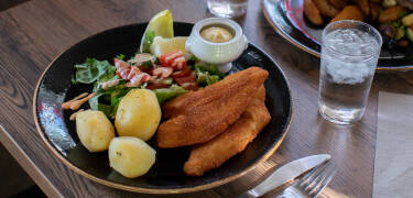 Etter en aktiv dag kan du nyte en deilig middag og slappe av i den koselige baren.