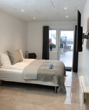 Geräumige Zimmer mit direktem Zugang zur Terrasse, inklusive Sitzgelegenheiten und Gartenblick.