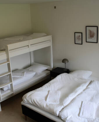 Entspannen Sie sich im gemütlichen Familienzimmer mit Etagenbett für die Kinder.