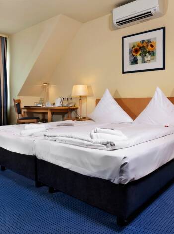 Hotellrummen är rymliga och ljust inredda med bekväma sängar.