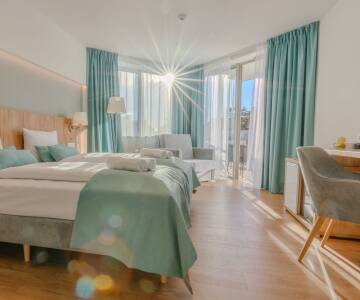 Buchen Sie eines der stilvollen und komfortablen Zimmer mit Balkon.