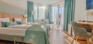 Buchen Sie eines der stilvollen und komfortablen Zimmer mit Balkon.