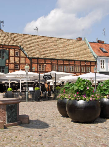 Promenera till Lilla Torg och upplev dess caféer och historiska byggnader.