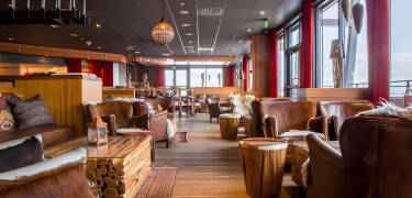 Naturlige materialer og åbne pejse giver interiøret en varm og elegant nordisk stemning.