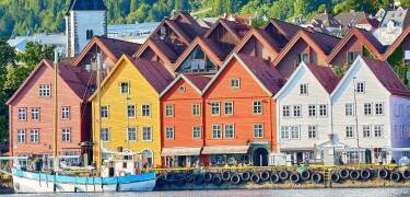 Visit Bryggen, Bergen’s historic harbor district, famous for its colorful wooden warehouses and narrow lanes.