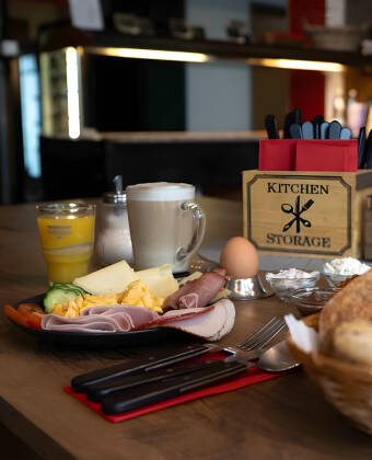 A varied breakfast with fresh fruit, cheeses, cold cuts, and hot dishes caters to different tastes.