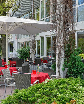 Nyt en liten snack eller kaffe utendørs på hotellets innbydende sommerterrasse.