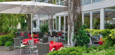 Genießen Sie einen Snack oder Kaffee im Freien auf der einladenden Sommerterrasse des Hotels.