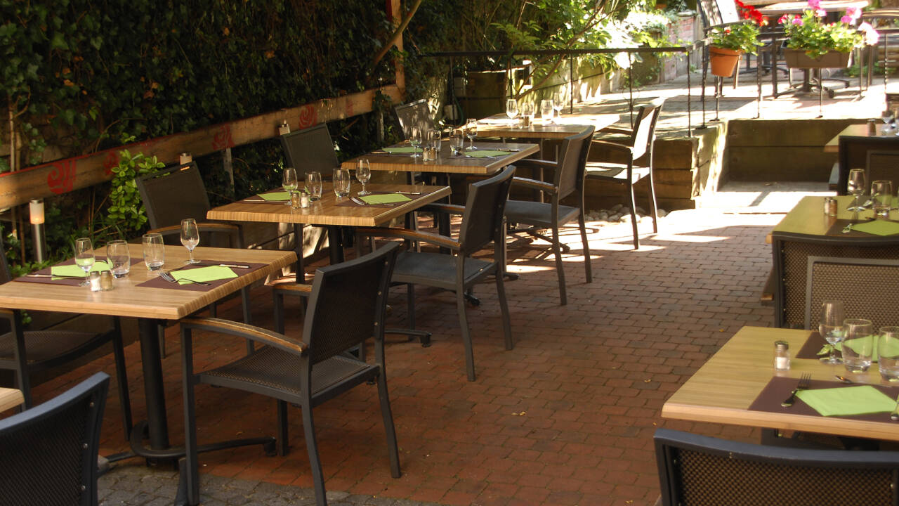 Nyd et glas vin på hotellets hyggelige terrasse, som er dekoreret med velduftende blomster.
