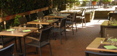 Nyd et glas vin på hotellets hyggelige terrasse, som er dekoreret med velduftende blomster.