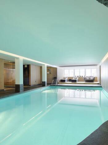 At First Mountain Hotel, unwind in a generous spa area with pool, saunas, and inviting relaxation spaces.