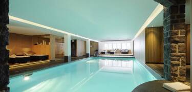 At First Mountain Hotel, unwind in a generous spa area with pool, saunas, and inviting relaxation spaces.