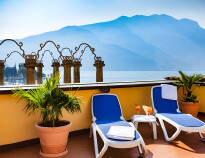 På hotellets takterrasse kan dere nyte en drink i solen og den flotte utsikten over Gardasjøen
