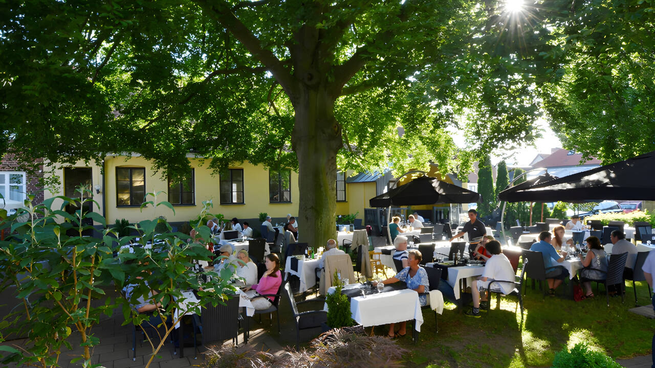 Im Sommer können Sie im schönen Gartenrestaurant unter dem riesigen Baum essen