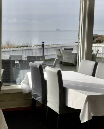 Genießen Sie die einladenden Speisen des Restaurants und den Blick aufs Meer.