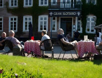 Ved godt vejr kan I sidde på gårdspladsen og nyde måltidet eller kaffen, med udsigt til slottet og søen.