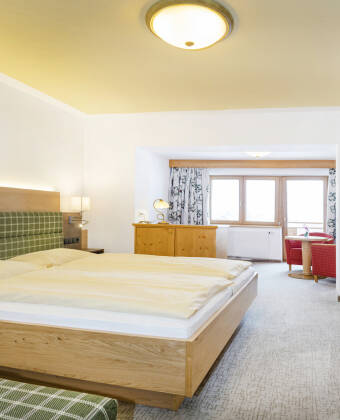 Hotellets rum är inredda i traditionell tyrolerstil, alla med balkong och idyllisk natur utanför fönstren.