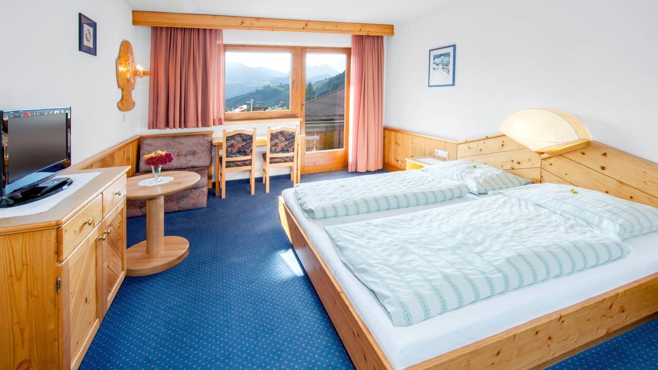 Hotellets værelser er indrettet i tradionel tyrolerstil, alle med balkon og idyllisk natur lige udenfor vinduerne.