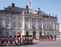 Gå förbi den danska kungafamiljens praktfulla palats och upplev den stämningen.