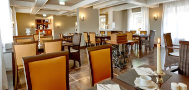 Dere nyter deres frokost i hotellets restaurant, som er innredet med fine, antikke møbler.