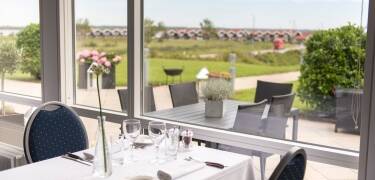Fra hotellets restaurant og terrasse er det en flott utsikt over området ned til vannet.