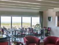 Genießen Sie die Atmosphäre im modernen Restaurant mit gemütlichem Kamin und einer herrlichen Aussicht auf das Meer