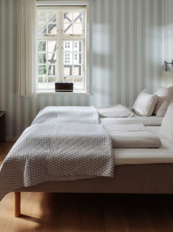 Die Zimmer im Gl. Avernæs Sinatur Hotel sind in natürlichen Farben mit skandinavischem Flair dekoriert.