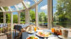 Beginnen Sie Ihren Tag mit einem reichhaltigen Frühstücksbuffet und genießen Sie den Blick auf den Garten vom Frühstücksraum des Hotels.